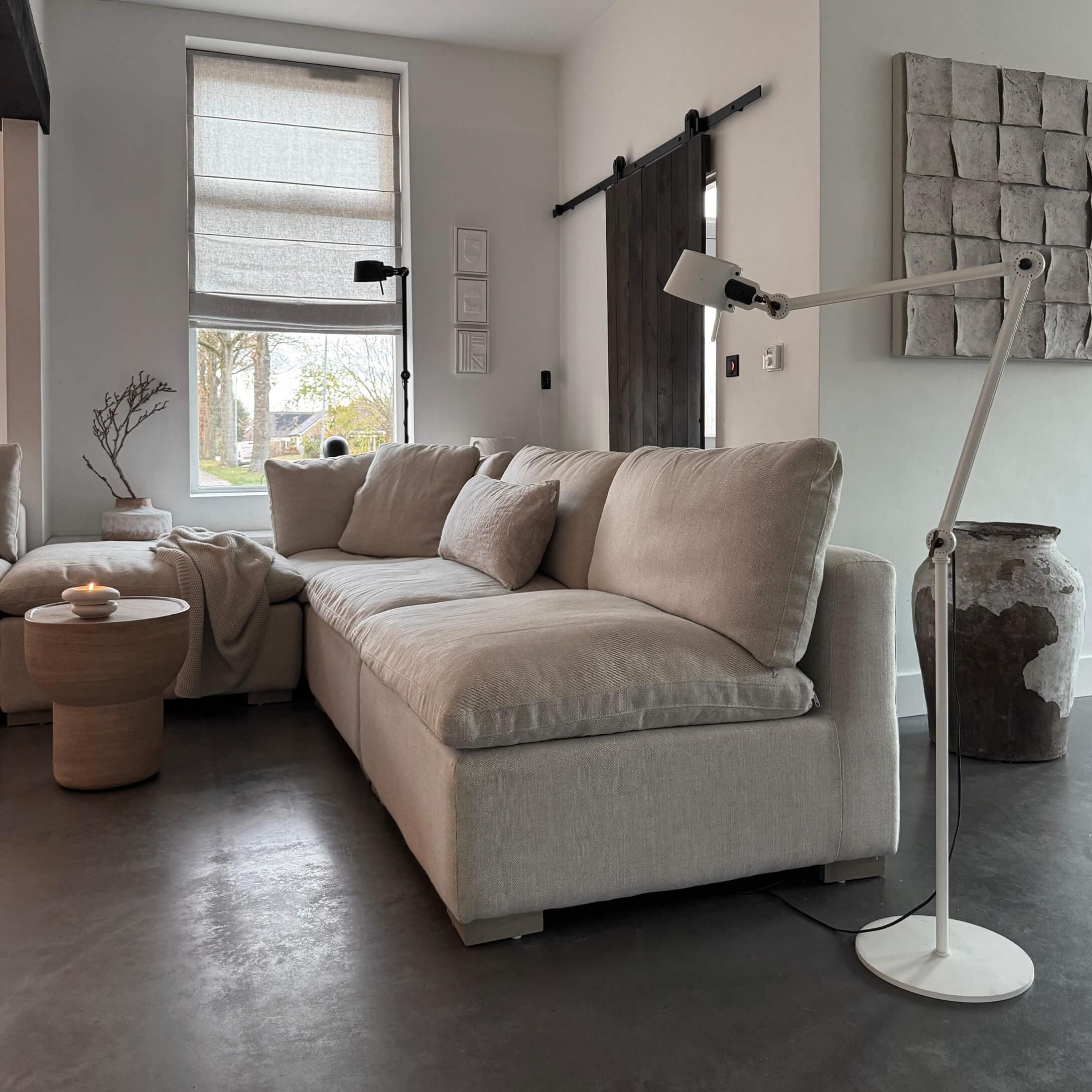Beige Eckcouch aus Stoff in modernem Wohnzimmer mit Stehlampe und Holzbeistelltisch