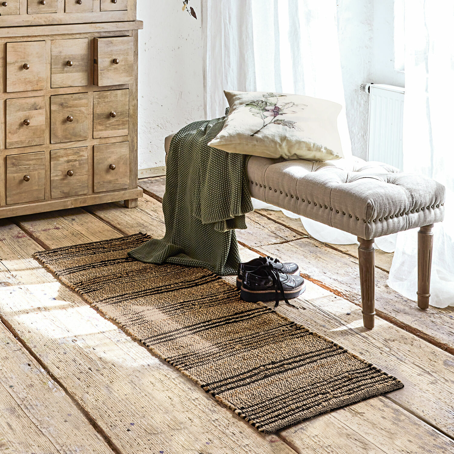 Schmaler Läufer aus Naturmaterial in Beige-Schwarz auf Holzboden in hellem Raum