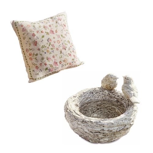 Dekoratives Blumenmuster-Kissen und steinerne Schale mit Vögeln im Shabby-Chic-Stil