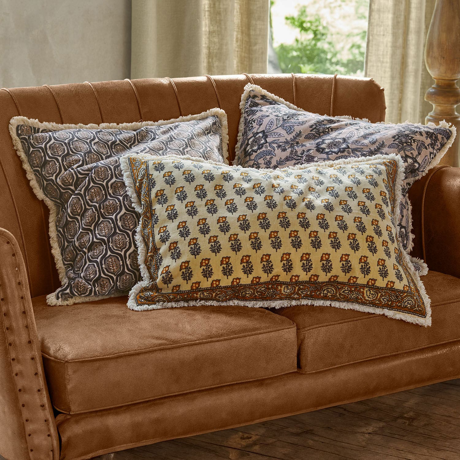Kissenhülle 3er Set Zandora Drei dekorative Baumwollkissen mit Blumenmuster auf braunem Sofa im Wohnzimmer
