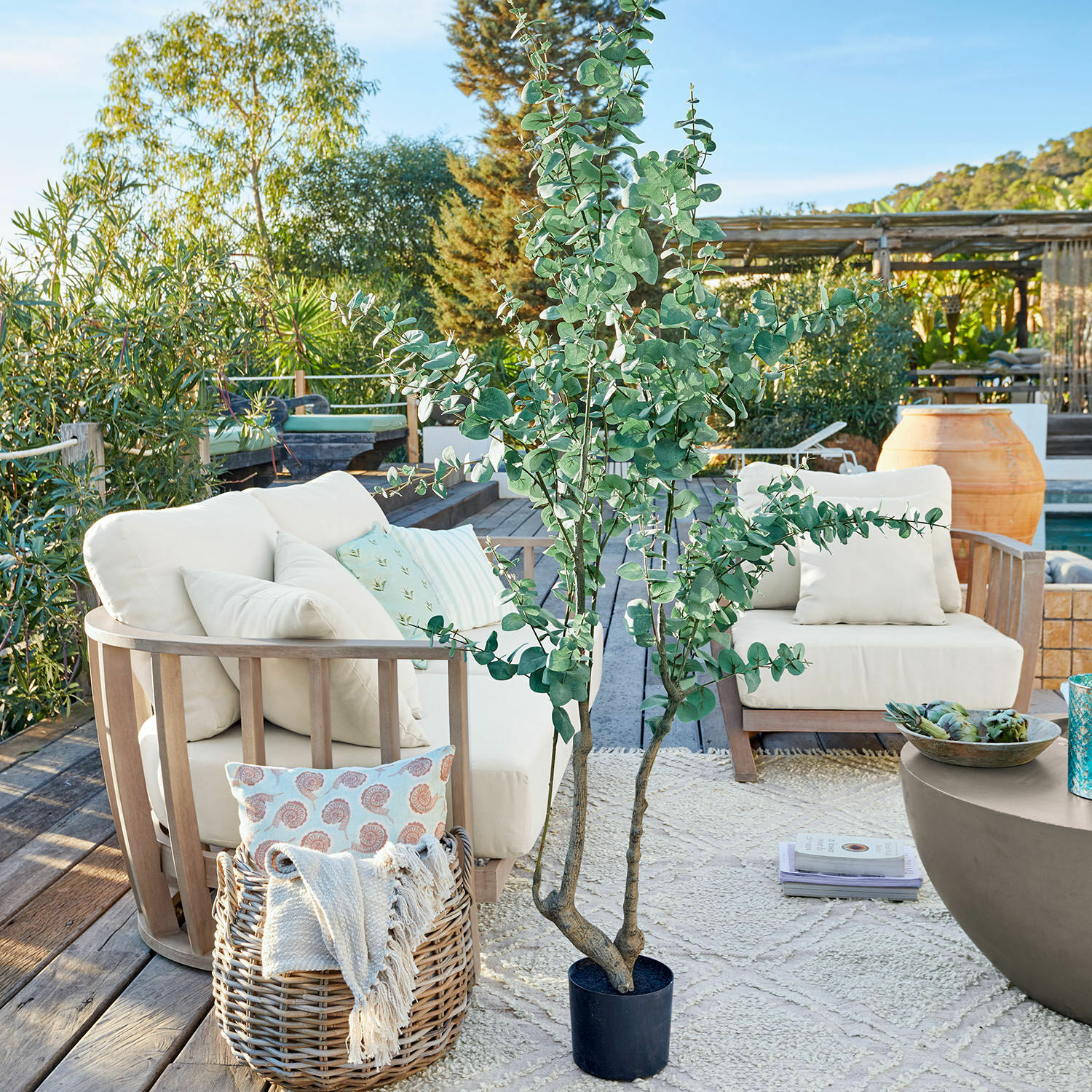 Deko-Topfpflanze Dorevi Großer künstlicher Eukalyptus in schwarzem Topf auf Terrasse mit Gartenmöbeln und Dekorationen