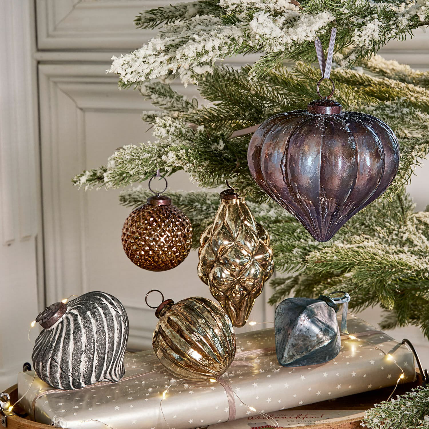 Weihnachtsschmuck 6er Set Alva Set aus braunen und silbernen Glas-Weihnachtskugeln an schneebedecktem grünen Zweig