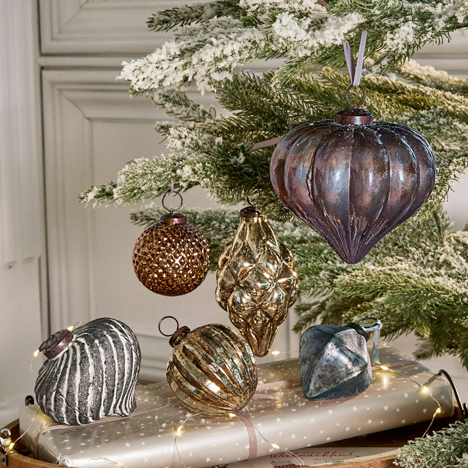 Weihnachtsschmuck 6er Set Alva Set aus braunen und silbernen Glas-Weihnachtskugeln an schneebedecktem grünen Zweig