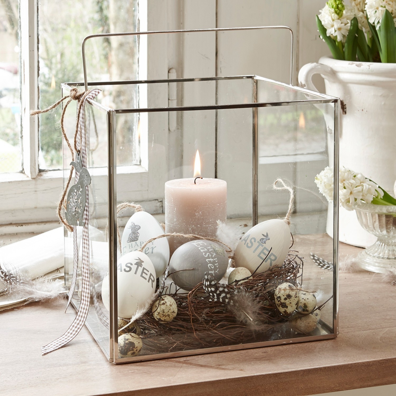 Windlicht Otero Glaslaterne mit Metallrahmen, dekoriert mit Oster-Eiern und Kerze auf Holztisch