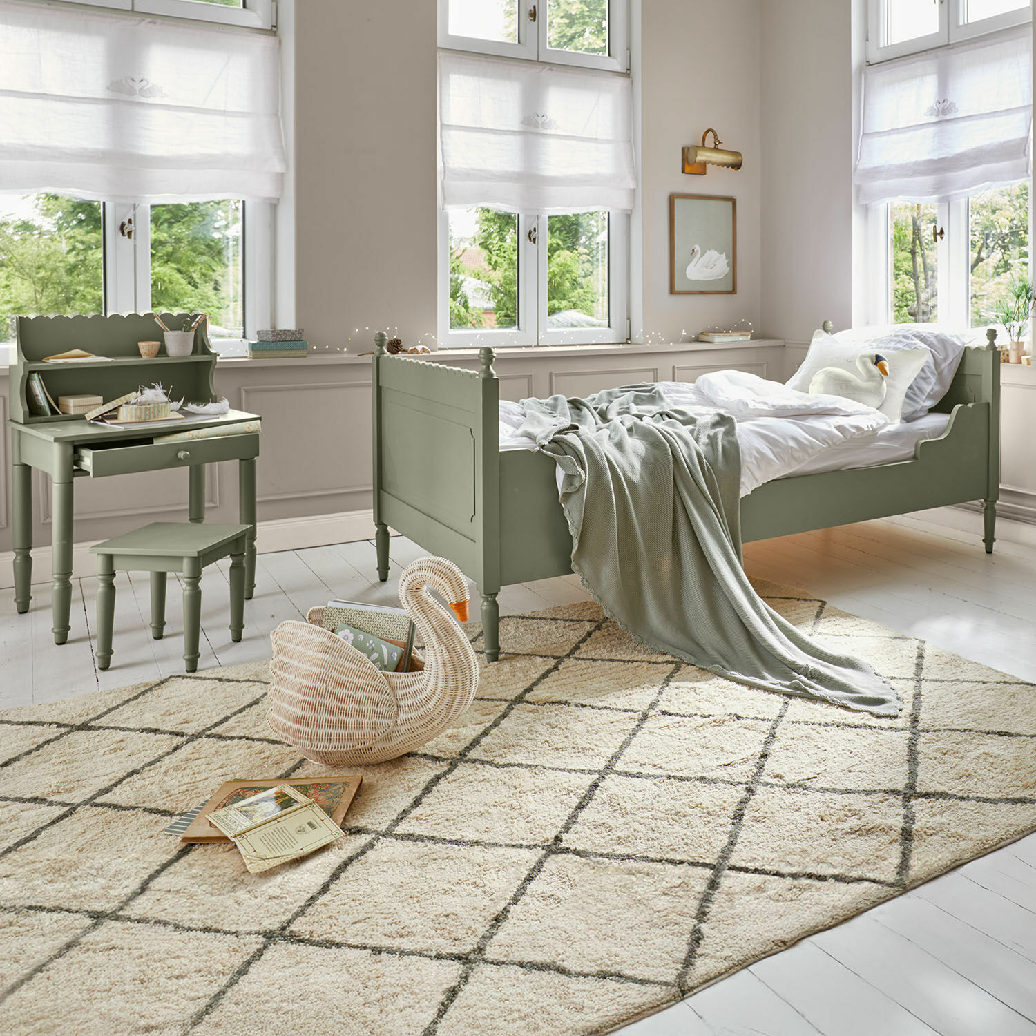 Kinderzimmer mit grünem Holzbett und Schreibtisch, heller Teppich mit geometrischem Muster, gemütlich