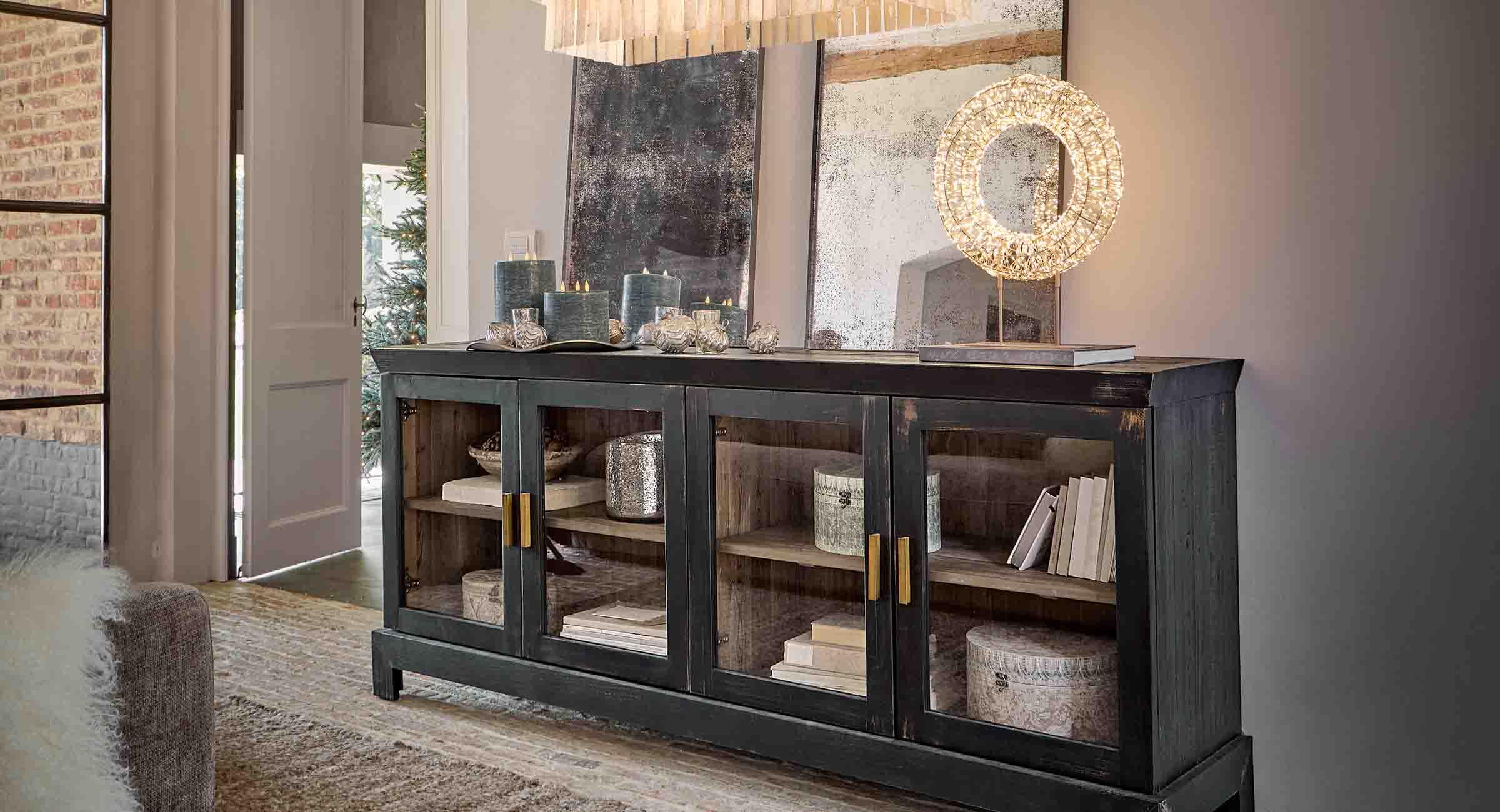 Schwarzer Holzschrank mit Glastüren und dekorativen Kerzen in einem stilvollen Wohnzimmer