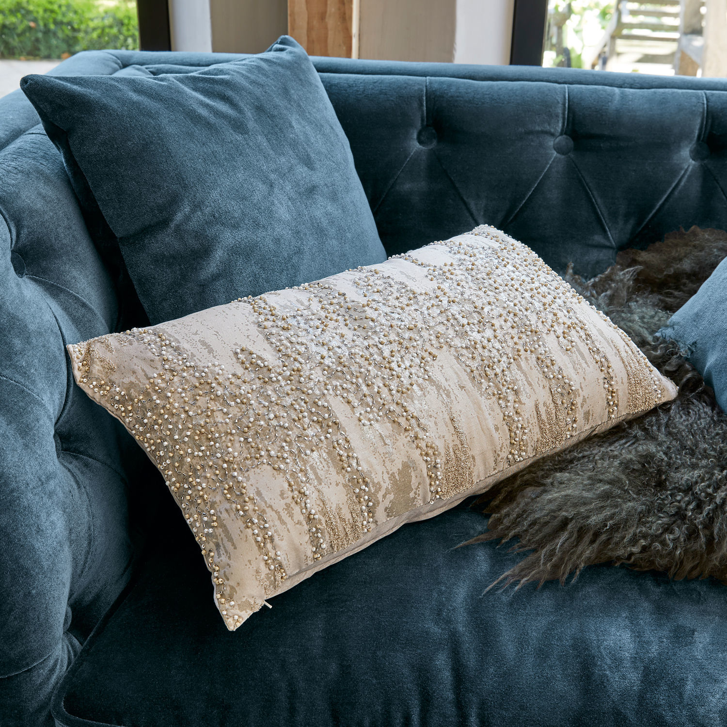 Kissenhülle Aparan Beige dekoratives Kissen mit Perlen auf blauem Samtsofa, stilvolles Wohnaccessoire