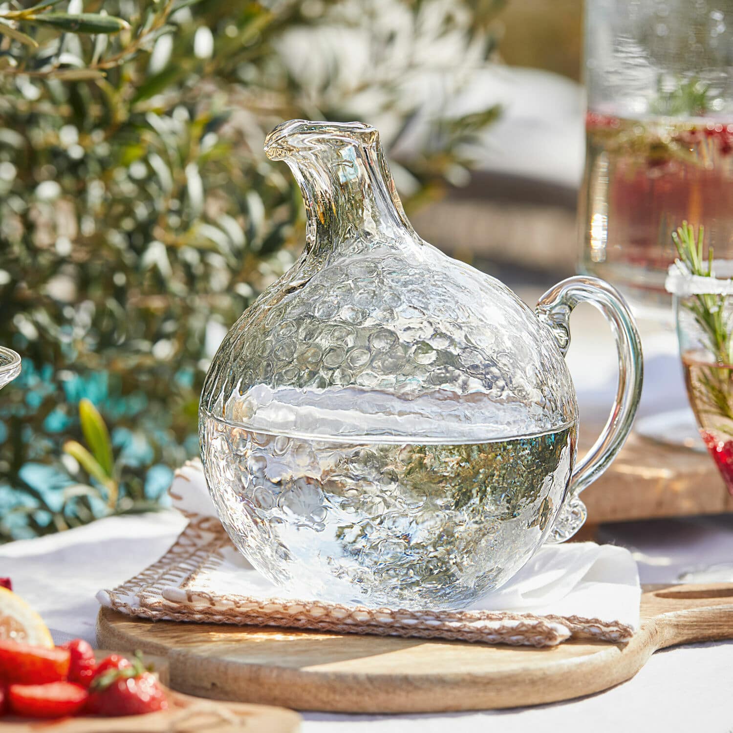 Krug Valters Glaskrug mit Blasenstruktur, transparent, auf Holzbrett, ideal für Getränke und Sommerpartys.