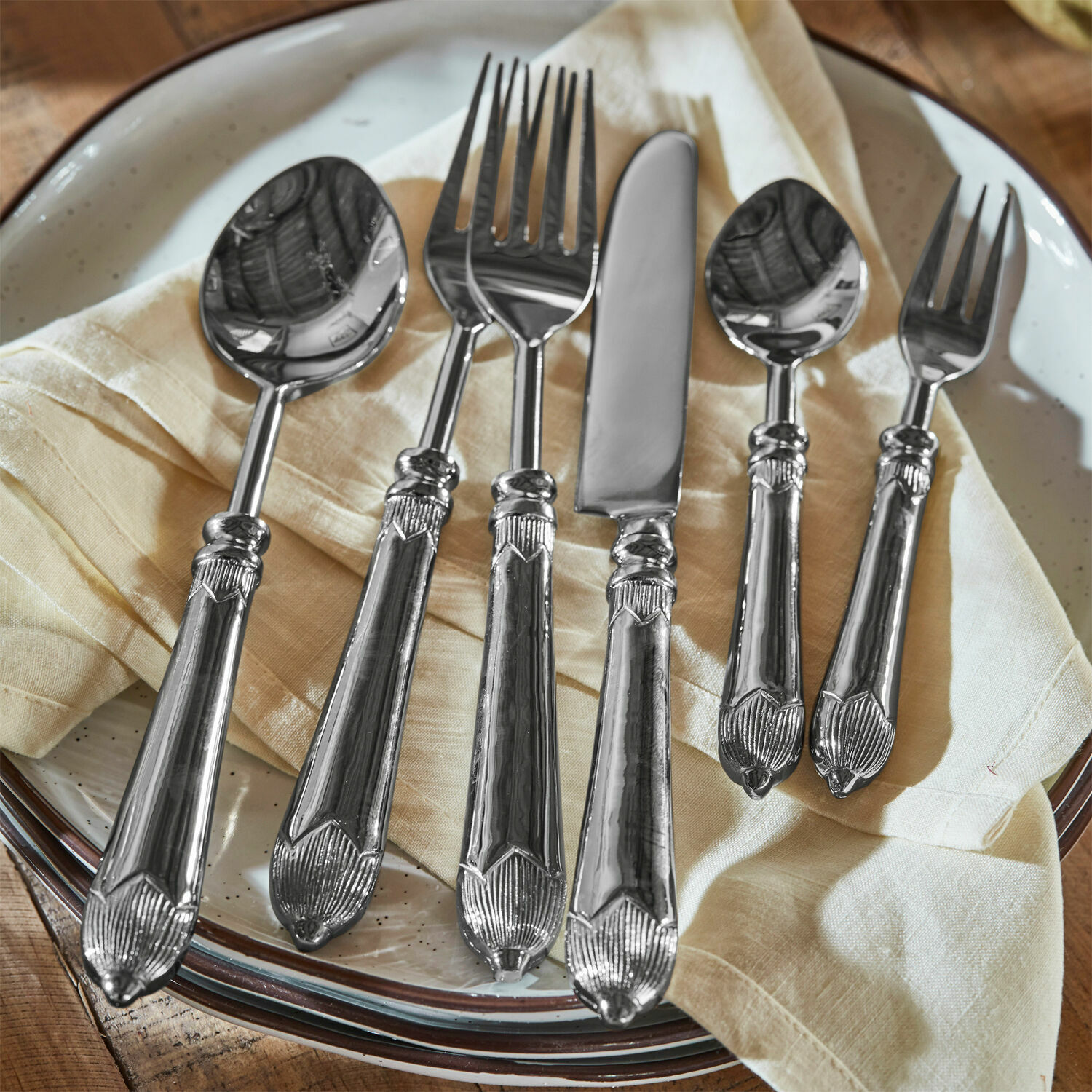 Besteck Gasharba Set silberner Edelstahlbestecke auf cremefarbener Serviette auf Teller, elegante Küchenaccessoires