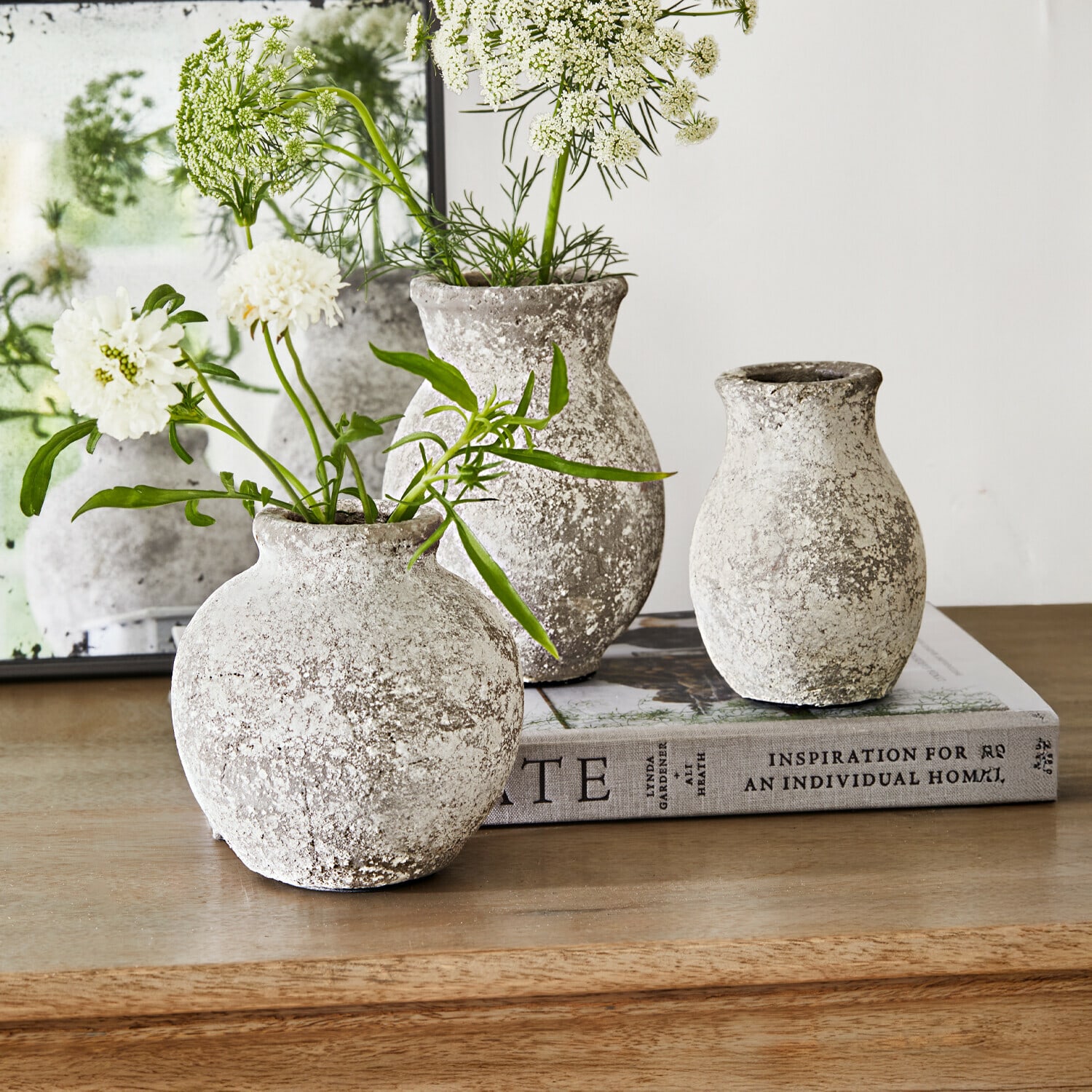 Vase 3er Set Cerquix Drei rustikale Steinvase in Grau-Weiß auf Holztisch mit weißen Blumen dekoriert