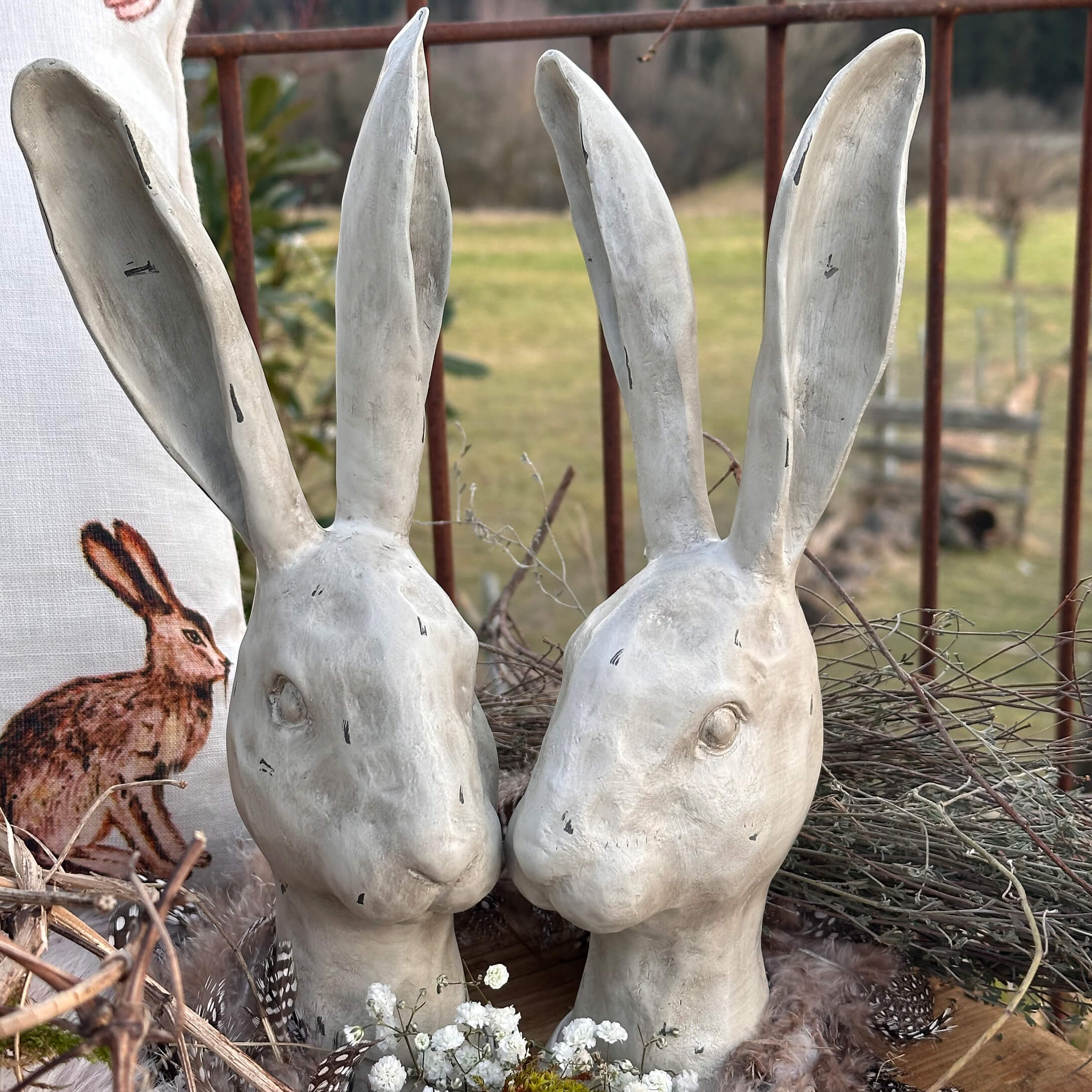 Weiße Keramik-Hasenköpfe mit langen Ohren als rustikale Osterdekoration im Landhausstil
