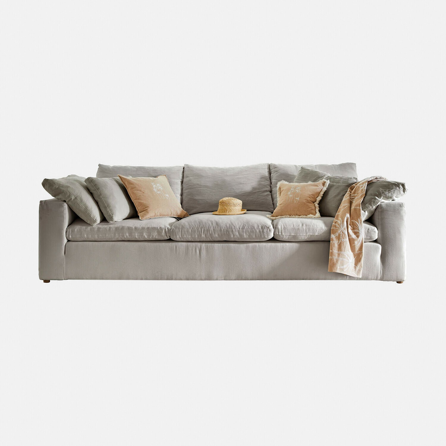 Graues Sofa aus Stoff mit beigen Kissen und Strohhut in der Mitte, modernes Wohnzimmermöbel