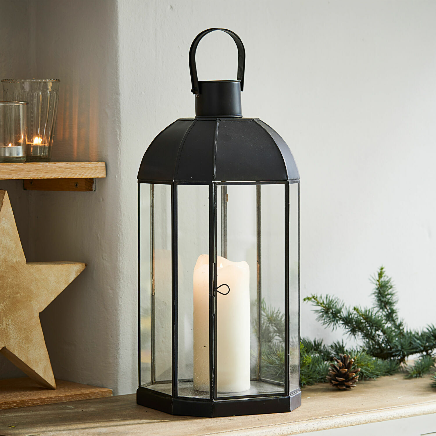 Laterne Comines Schwarze Metalllaterne mit klarem Glas und weißer Kerze auf Holztisch mit Weihnachtsdeko