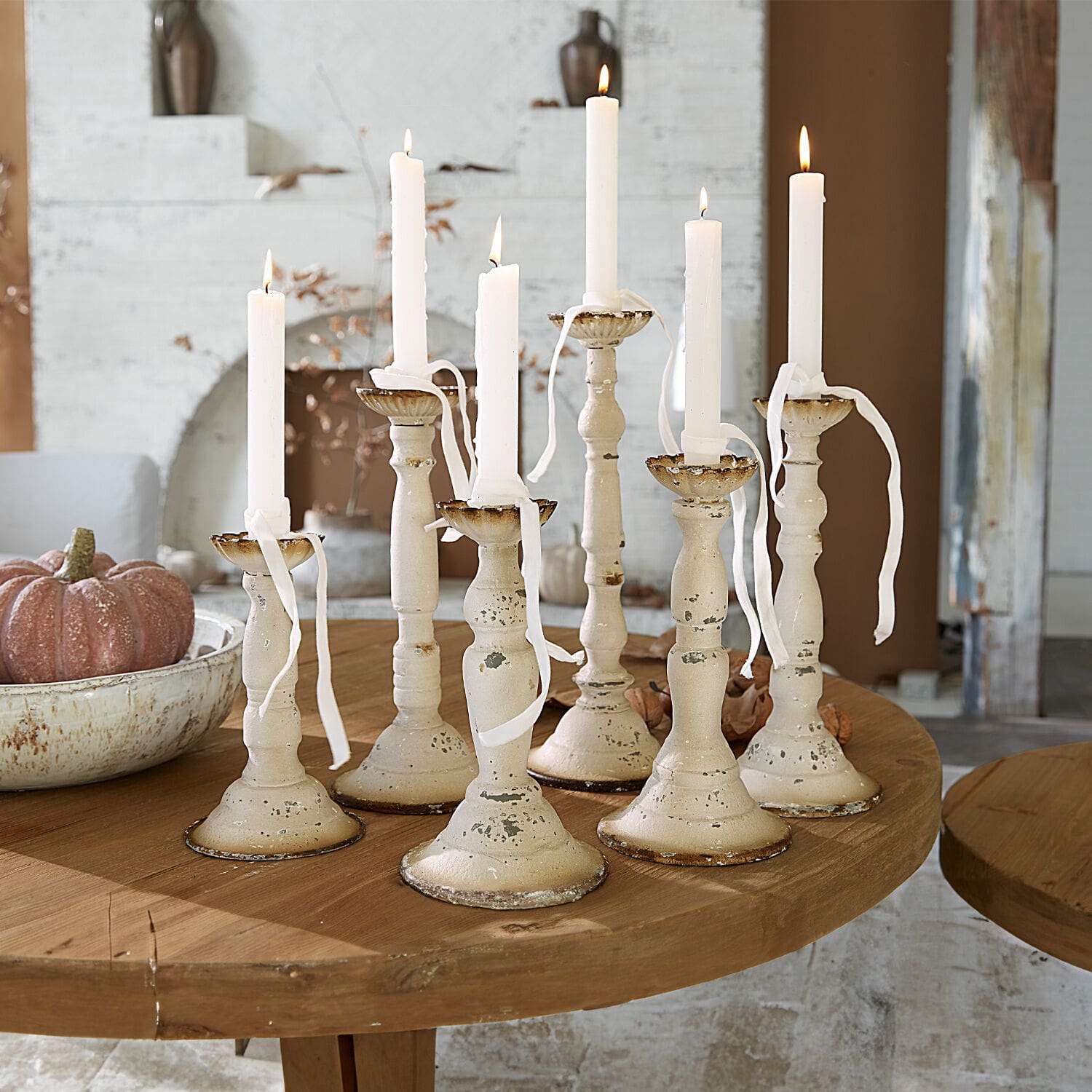 Kerzenhalter 6er Set Rivondelle Set aus sieben cremefarbenen Metallkerzenhaltern mit weißen Kerzen auf Holztisch, Wohnraumdeko