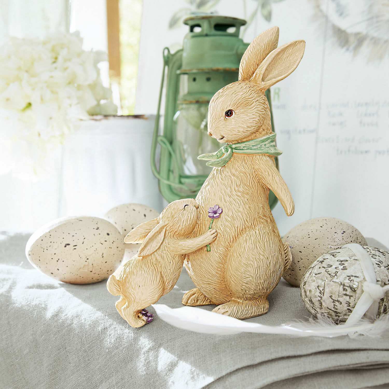 Deko-Hasen Susans Beige Resin-Hasenfiguren auf dekorativem Tisch mit Ostereiern als Frühlingsdeko