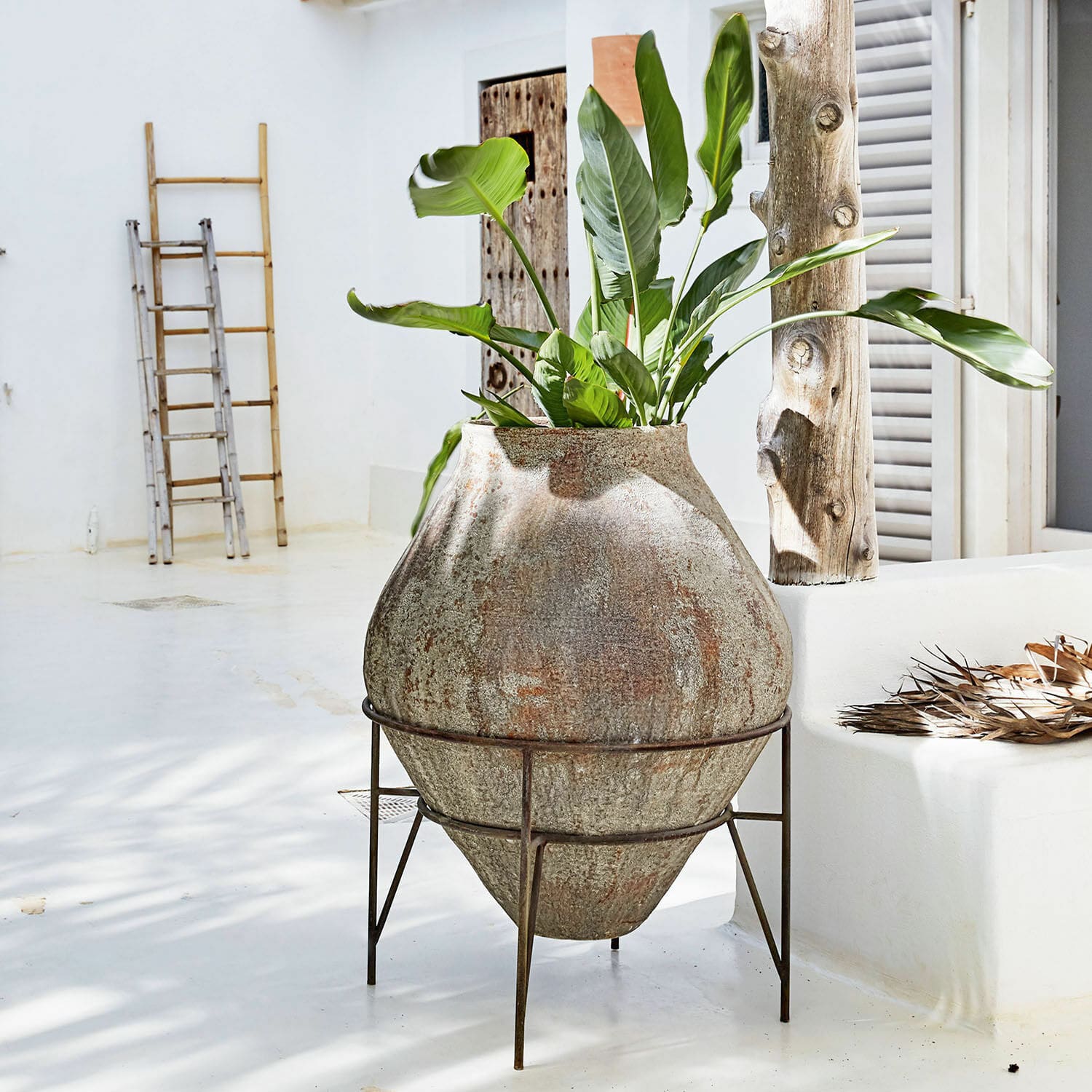 Vase Pive Großer Steintopf auf Metallständer mit grüner Pflanze in hellem, minimalistischem Raum