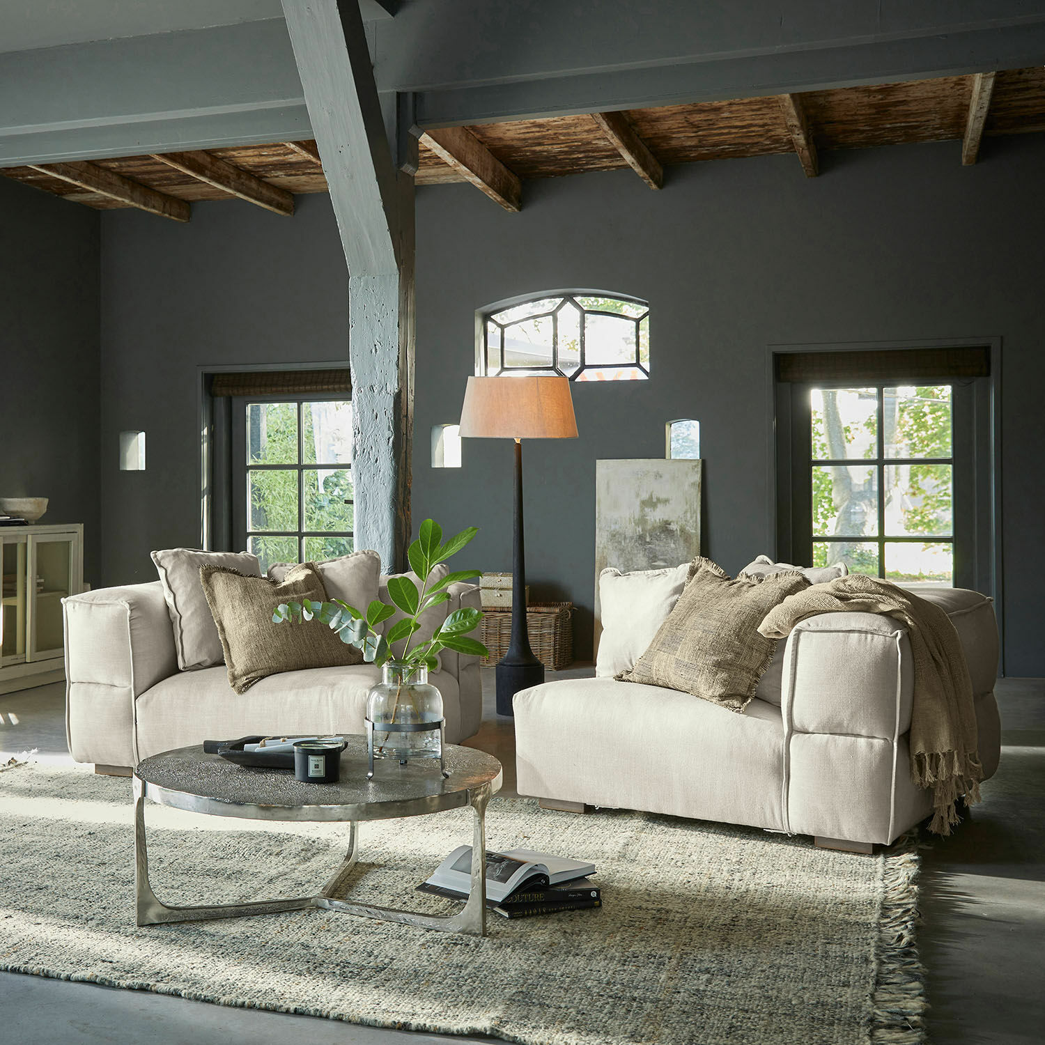Beige Stoffsofa in modernem Wohnzimmer mit Metall-Couchtisch und Stehlampe für gemütliche Atmosphäre
