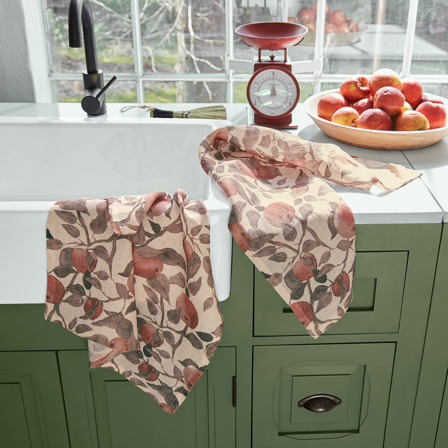 Leinen-Geschirrtücher mit Apfelmuster auf grünem Schrank am Spülbecken, Küchenaccessoire
