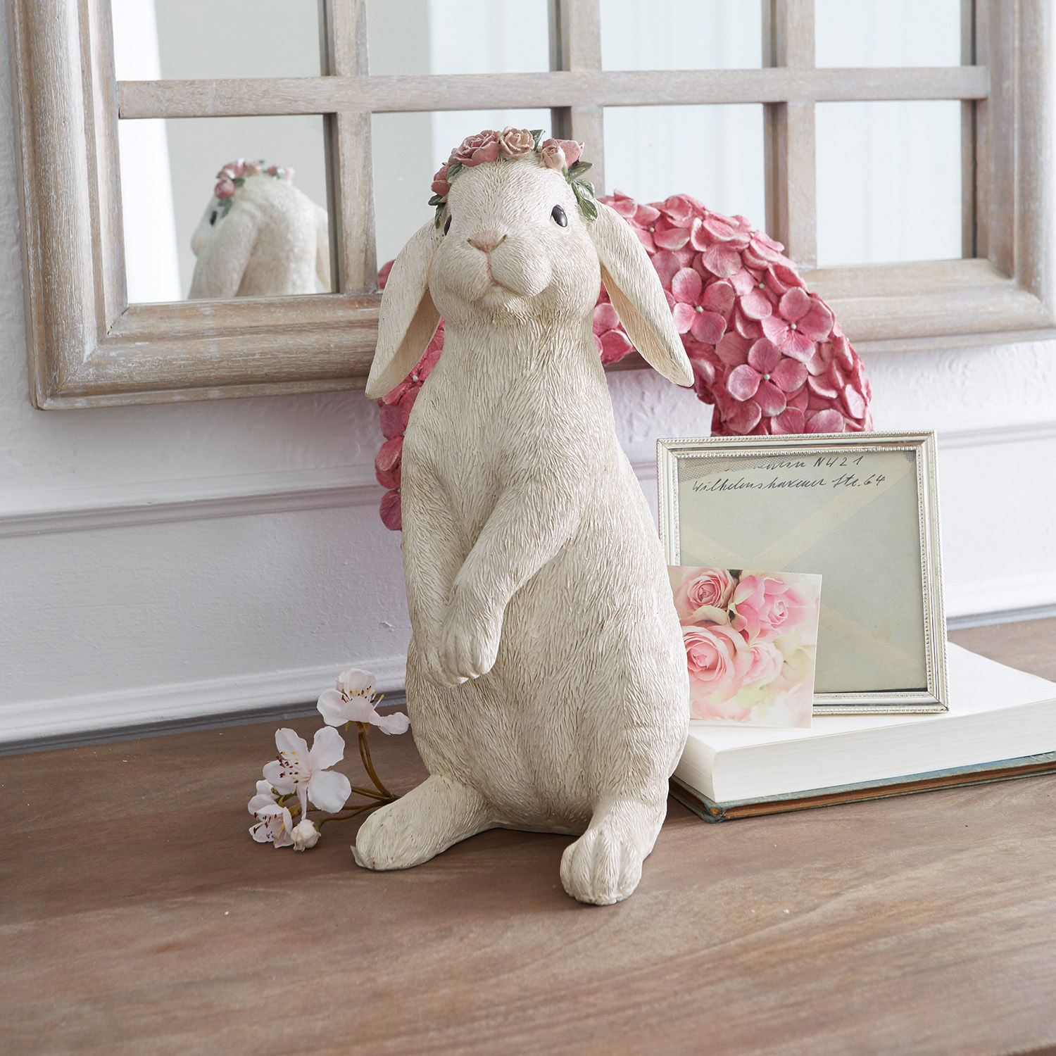Hase Sweety Kaninchenfigur aus cremefarbenem Material mit rosa Blumenkranz auf dekoriertem Tisch