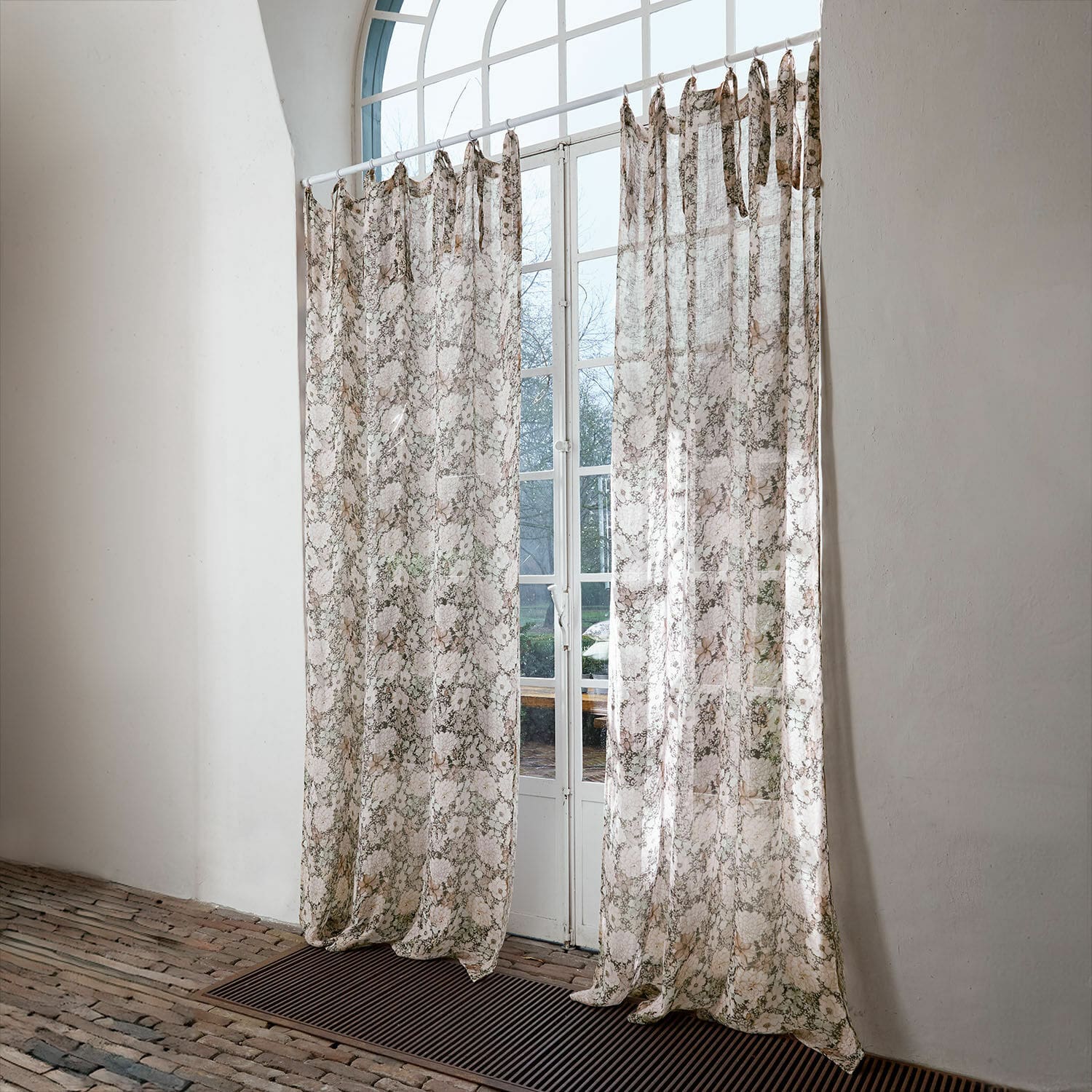 Gardine Cappellina Transparente Vorhänge mit zartem Muster in Beige- und Brauntönen vor weißem Fenster