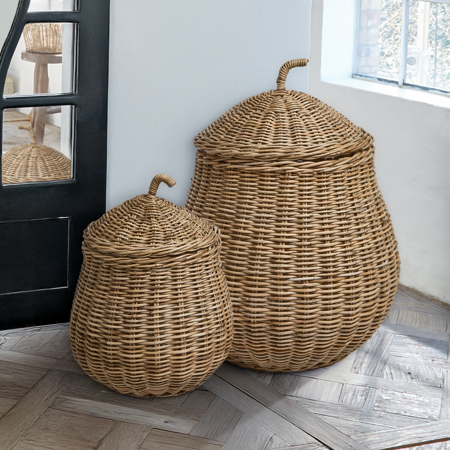 Korb 2er Set Fernn Zwei naturfarbene Rattankörbe mit Deckeln auf Holzboden neben Fenster, Wohnaccessoire