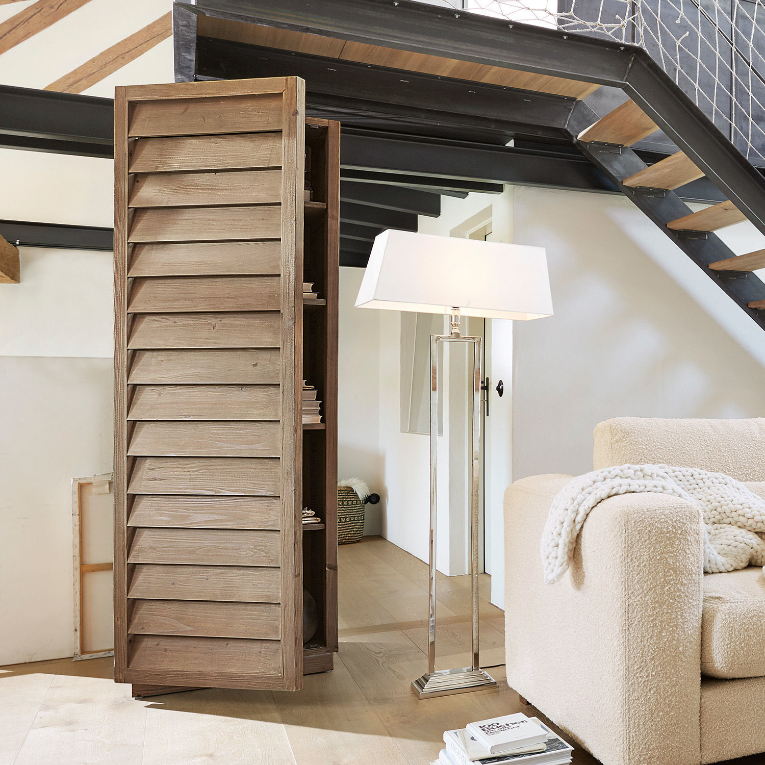 Schrank Bordó Holzschrank mit lamellenförmigen Türen in Naturfarbe im modernen Wohnzimmer mit Stehlampe und Sofa