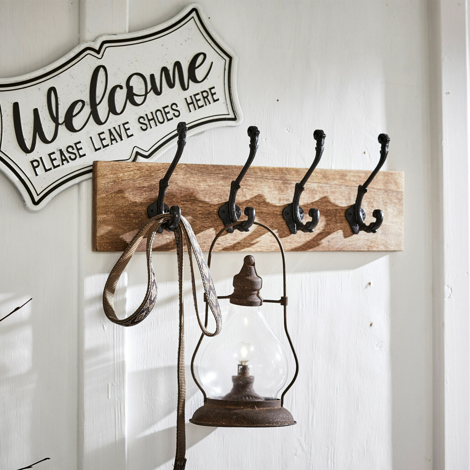 Hakenleiste Taylors Island Wandgarderobe aus Holz mit vier schwarzen Metallhaken und einer Vintage-Lampe