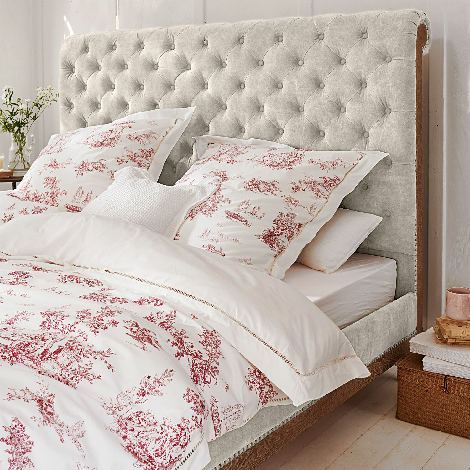 Bettwäsche Toile rouge Bett mit hellgrauem, gesteppter Kopfteil und Holzrahmen in gemütlichem Schlafzimmer