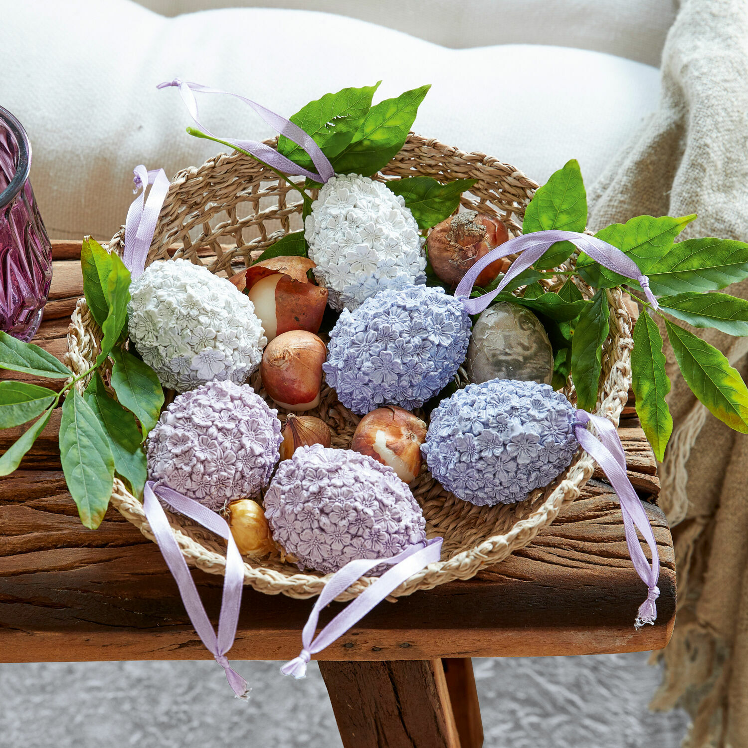 Osterei 6er Set Rigaud Korb mit pastellfarbenen Deko-Eiern mit Blumenmuster und grünen Blättern auf rustikalem Holztisch