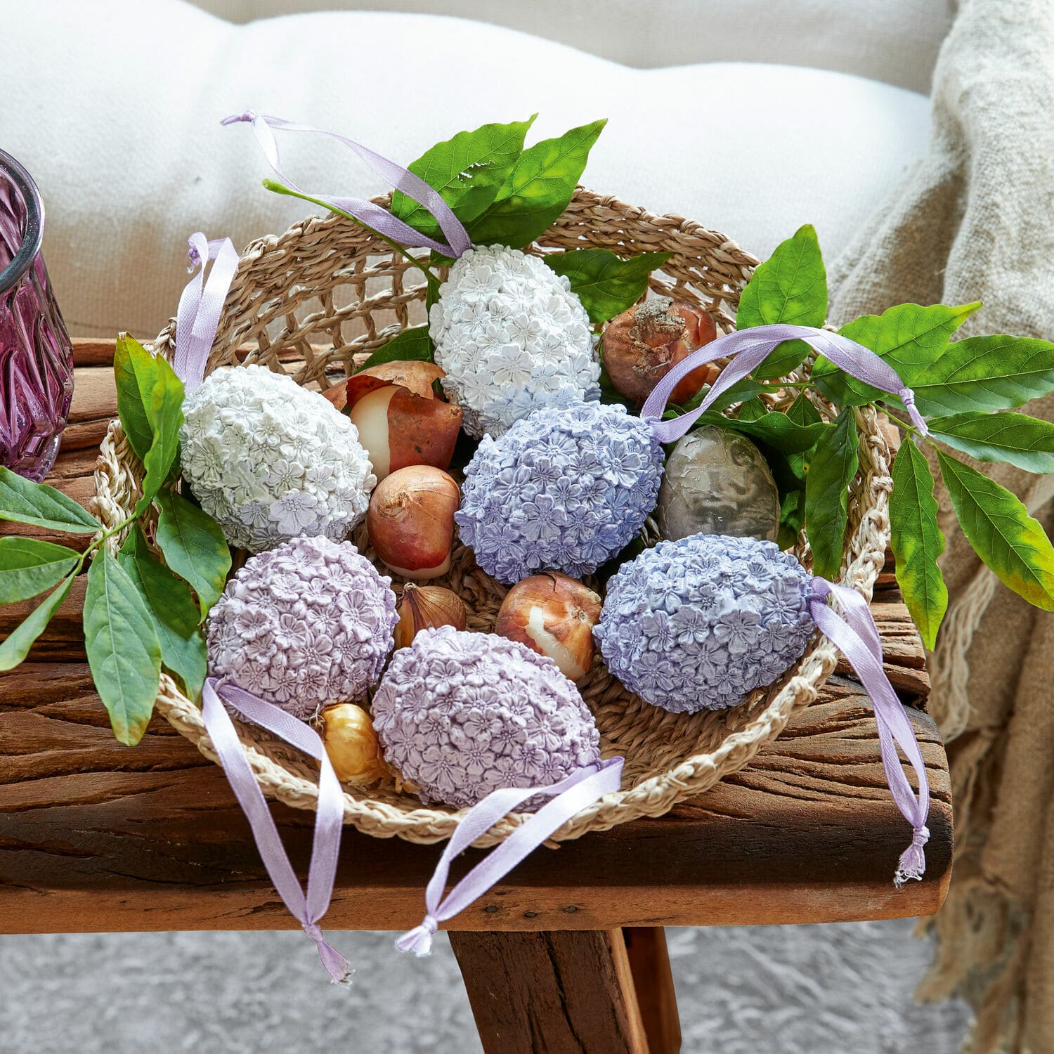Osterei 6er Set Rigaud Korb mit pastellfarbenen Deko-Eiern mit Blumenmuster und grünen Blättern auf rustikalem Holztisch