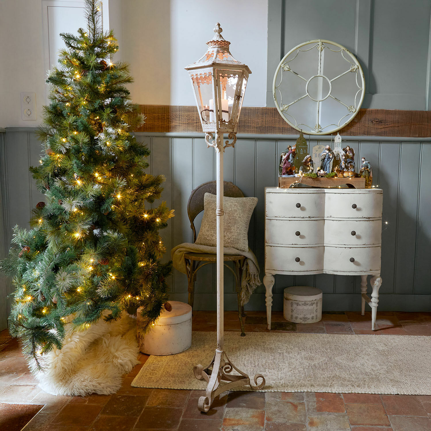 Laterne Lumière Élysée Weiße Metall-Stehlaterne mit dekorativem Muster in rustikalem Raum mit Weihnachtsbaum und Kommode