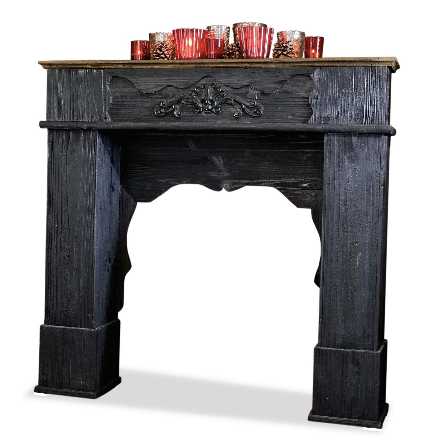 Kaminkonsole Margaux Schwarzer Holz-Kaminumrahmung mit dekorativem Schnitzdetail und roten Kerzen als Dekoration