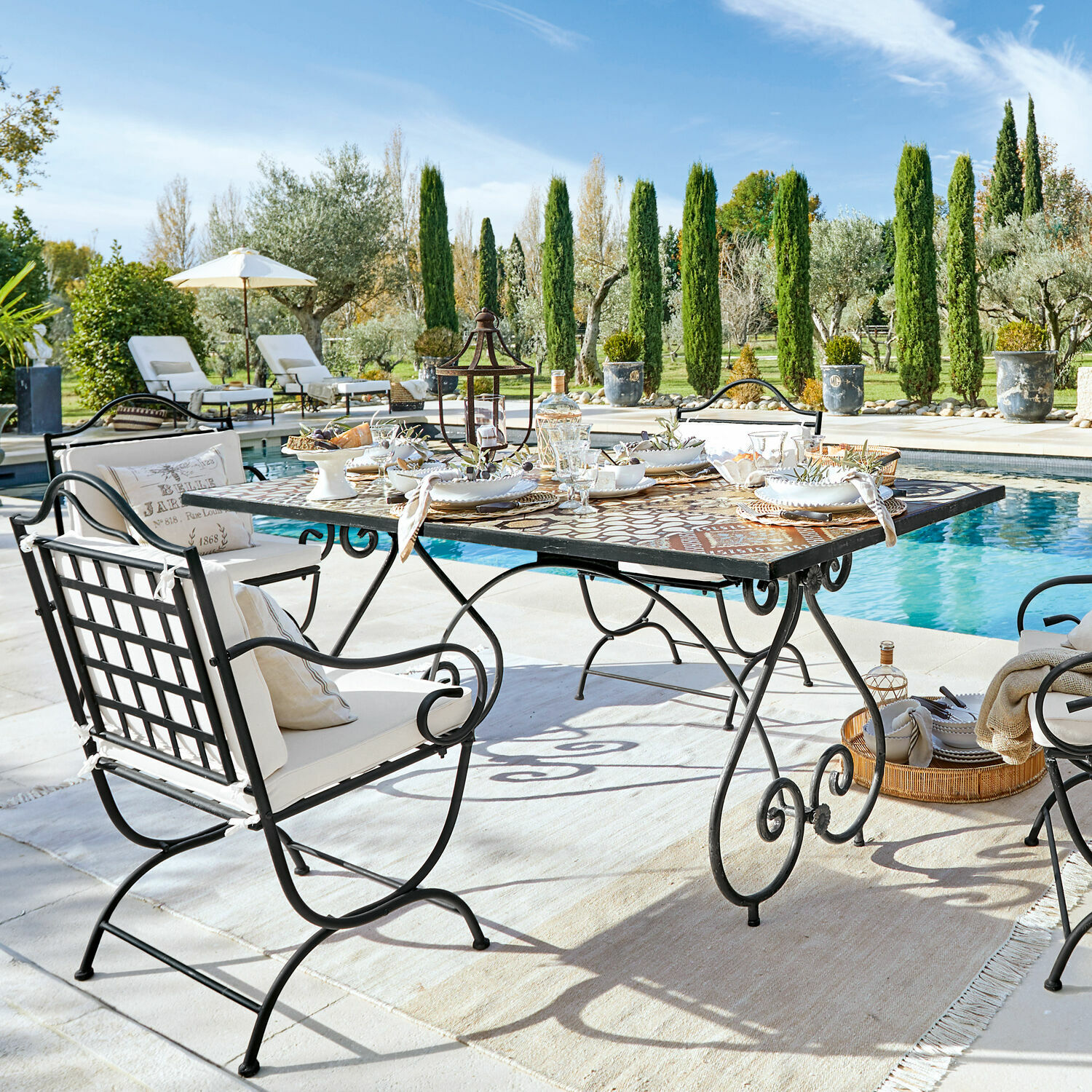 Tisch Grainville Gartenmöbel-Set aus Metall mit Mosaiktisch am Pool an sonnigem Tag