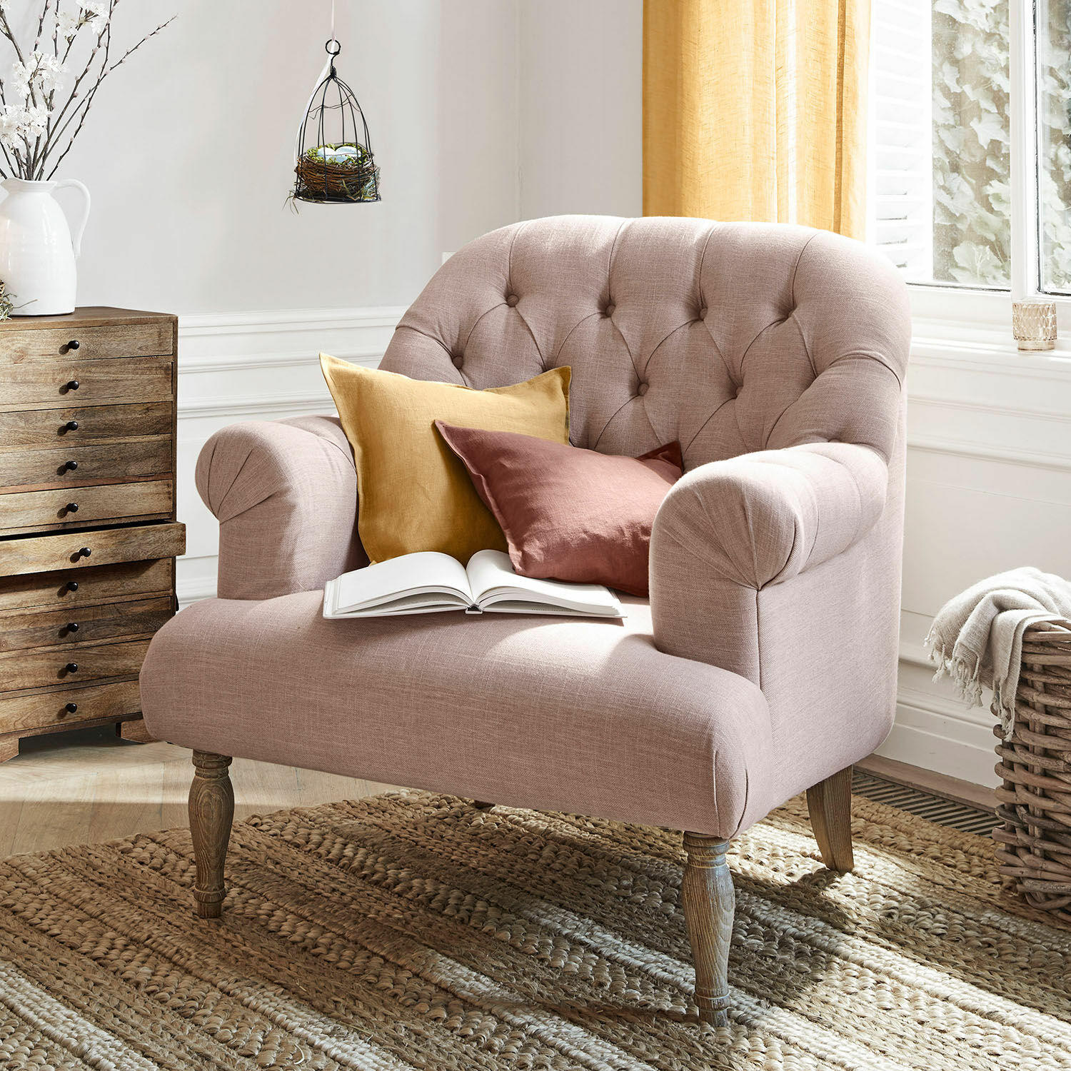 Sessel Shambrook Rosa gepolsterte Couch mit Holzbeinen und zwei farbigen Kissen auf gewebtem Naturteppich