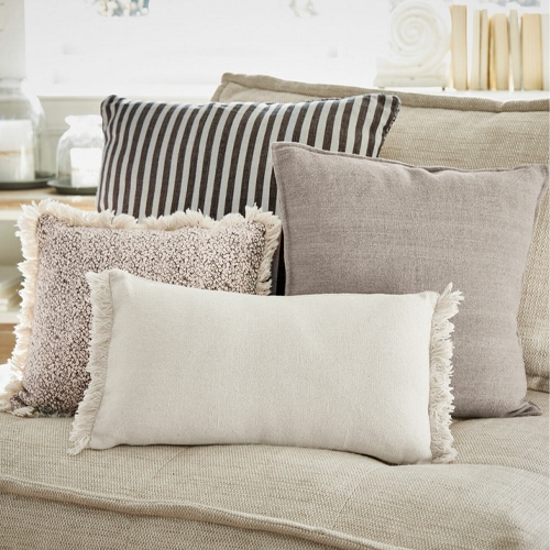 Set aus dekorativen Kissen in Beige- und Brauntönen auf beigem Sofa, weiche Materialien, Wohnzimmerdeko