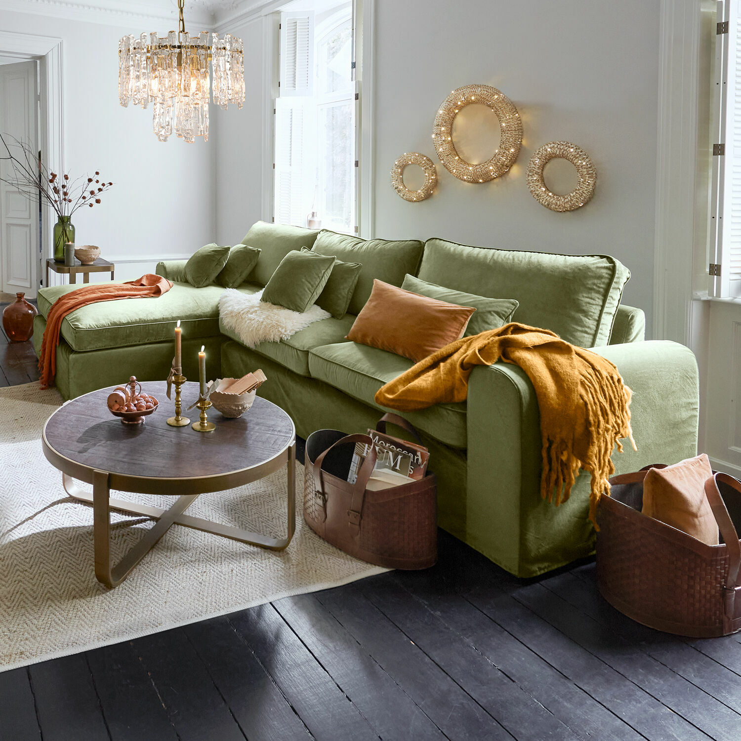 Sofa Seaford Grünes Samtsofa mit Kissen und orangefarbener Decke in modernem Wohnzimmer mit dekorativer Beleuchtung