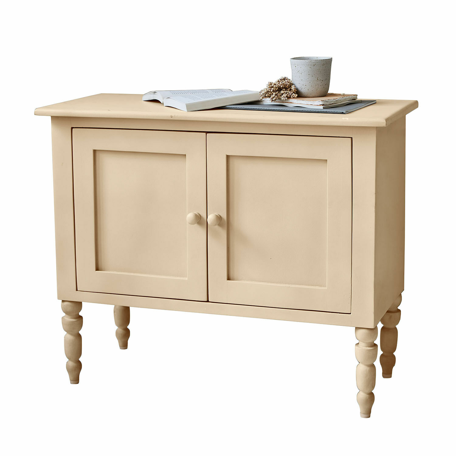 Beige lackierter Holzschrank mit zwei Türen und gedrechselten Beinen, Stauraummöbel fürs Wohnzimmer