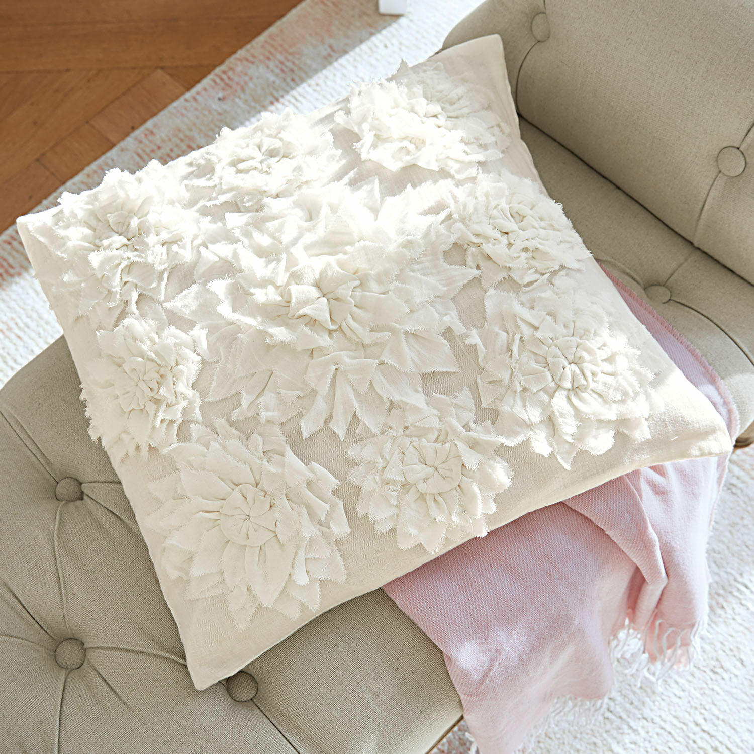 Kissenhülle Dorevil Beige Dekokissen mit floralen Stoffapplikationen auf grauem Sofa mit rosa Decke