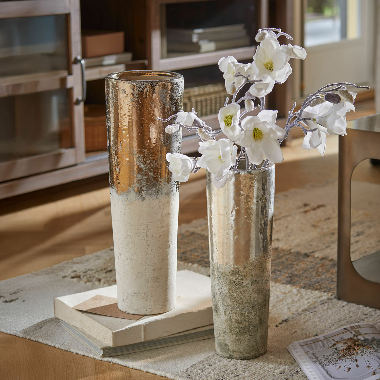 Vase 2er Set Tameena Zwei hohe Keramikvasen in Weiß und Silber auf Teppich mit weißen Blumen im Wohnzimmer