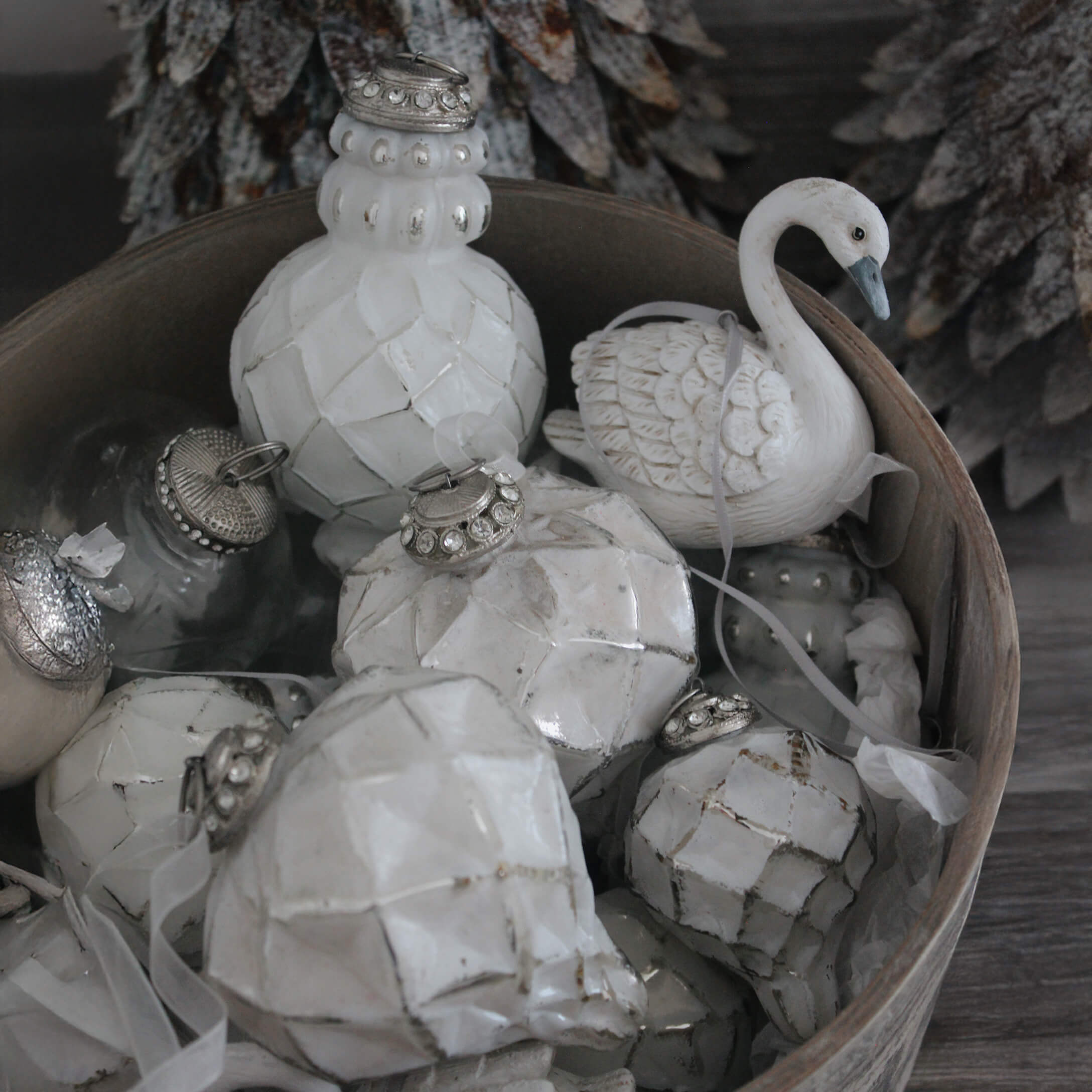 Weiße Weihnachtsdekorationen aus Keramik und Glas in einer Holzkiste, winterliche Ornamente