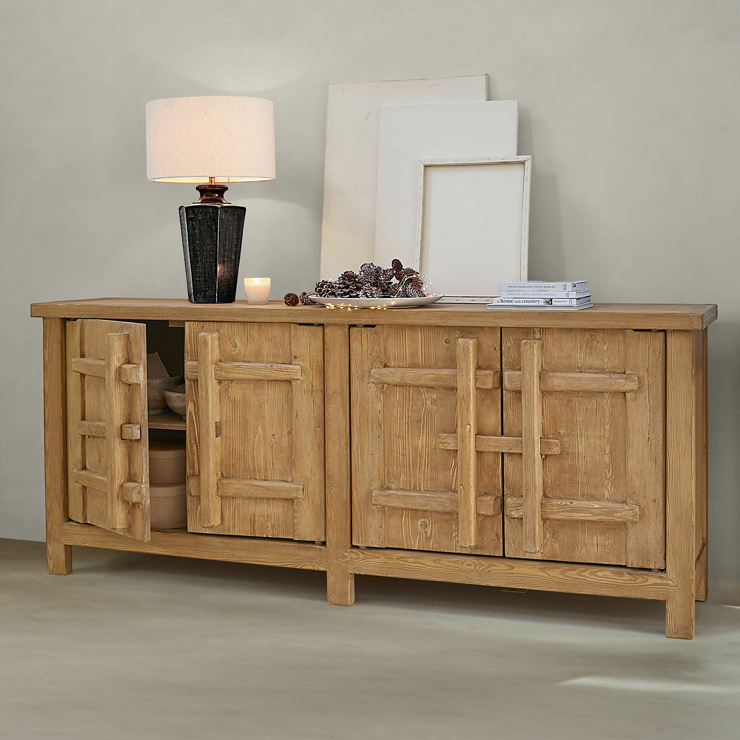 Sideboard aus naturbelassenem Holz mit vier Türen, Lampe und Dekorationen auf der Oberfläche