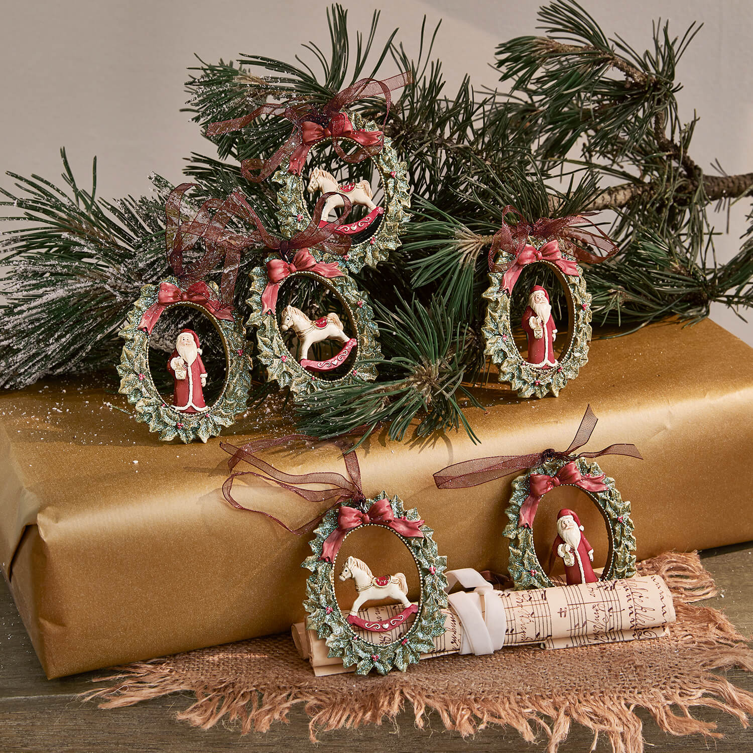 Set aus Weihnachtsanhängern mit grünen Kränzen, roten Schleifen und Figuren von Weihnachtsmann und Schaukelpferd