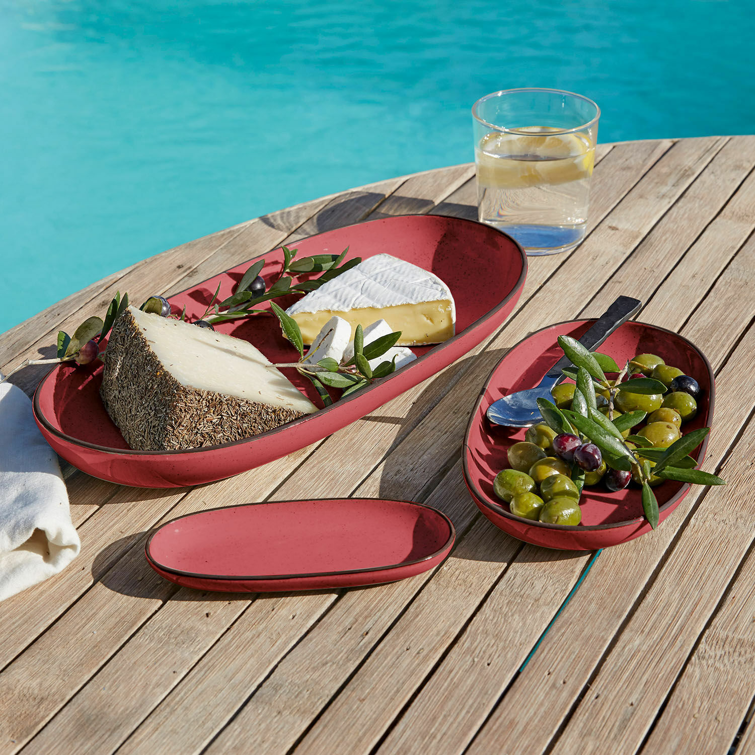 Servierplatte 3er Set Biarré Rote ovale Keramikteller mit Käse und Oliven auf Holztisch am Pool