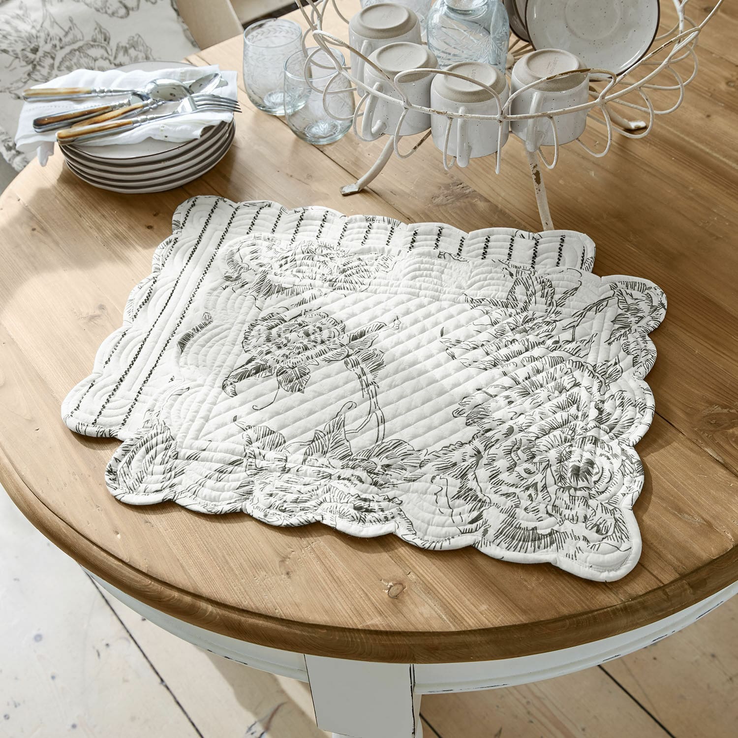 Platzset 2er Set Calarion Weiße gesteppte Tischunterlage mit schwarzem Blumenmuster auf Holztisch zur Wohnraumdekoration