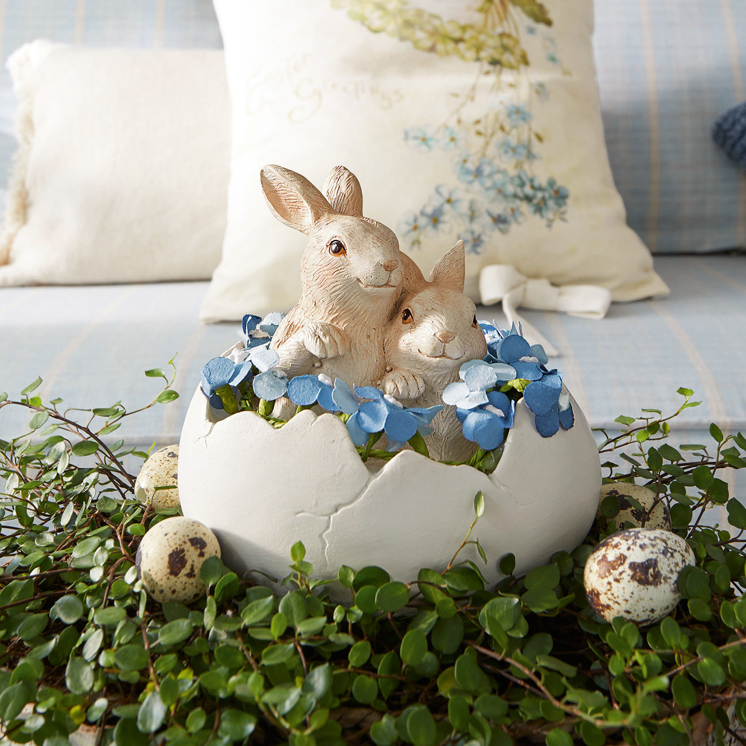 Hasen mit Ei Miksa Dekoration mit zwei Hasen in weißer Eierschale, blauen Blumen und grünem Blattwerk