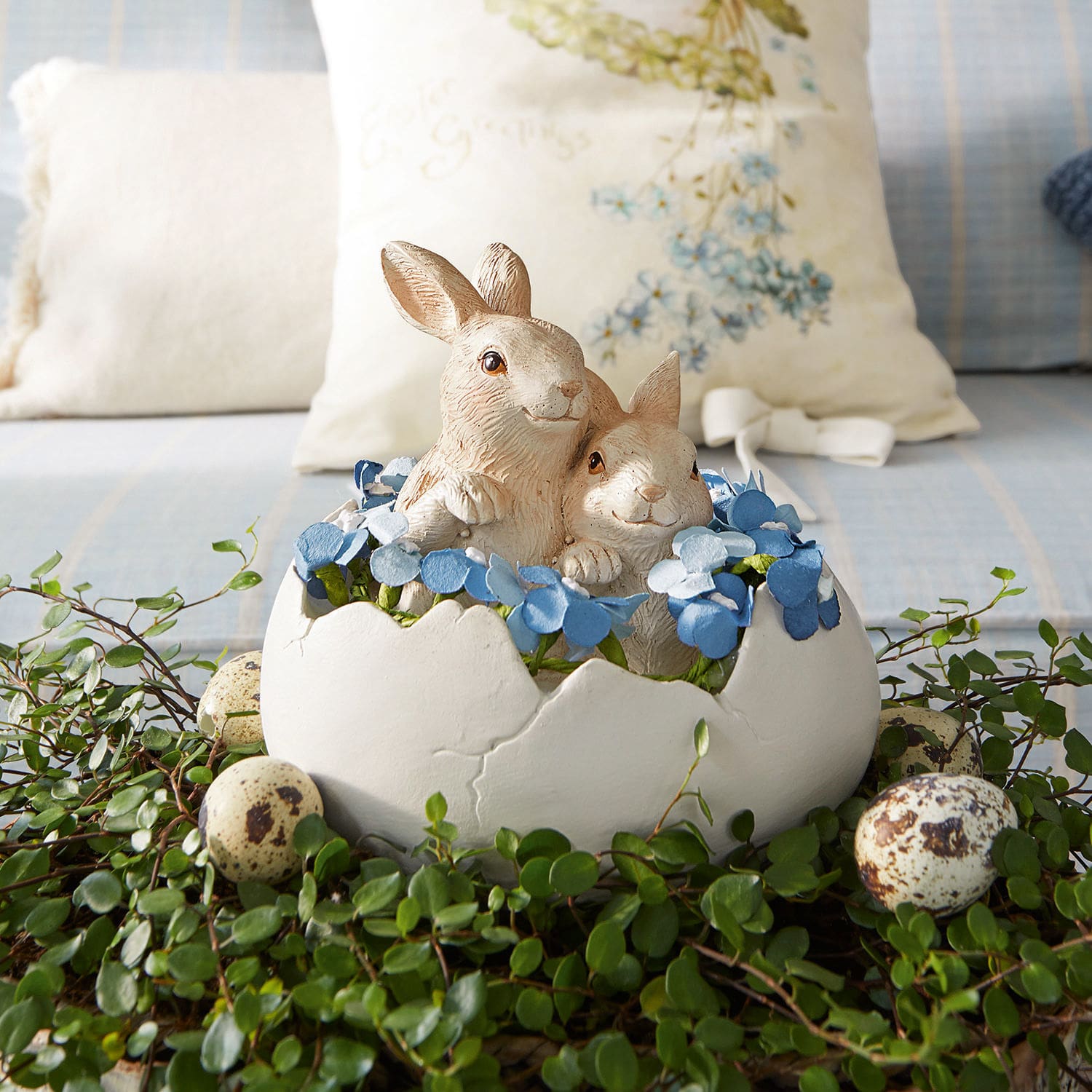Hasen mit Ei Miksa Dekoration mit zwei Hasen in weißer Eierschale, blauen Blumen und grünem Blattwerk