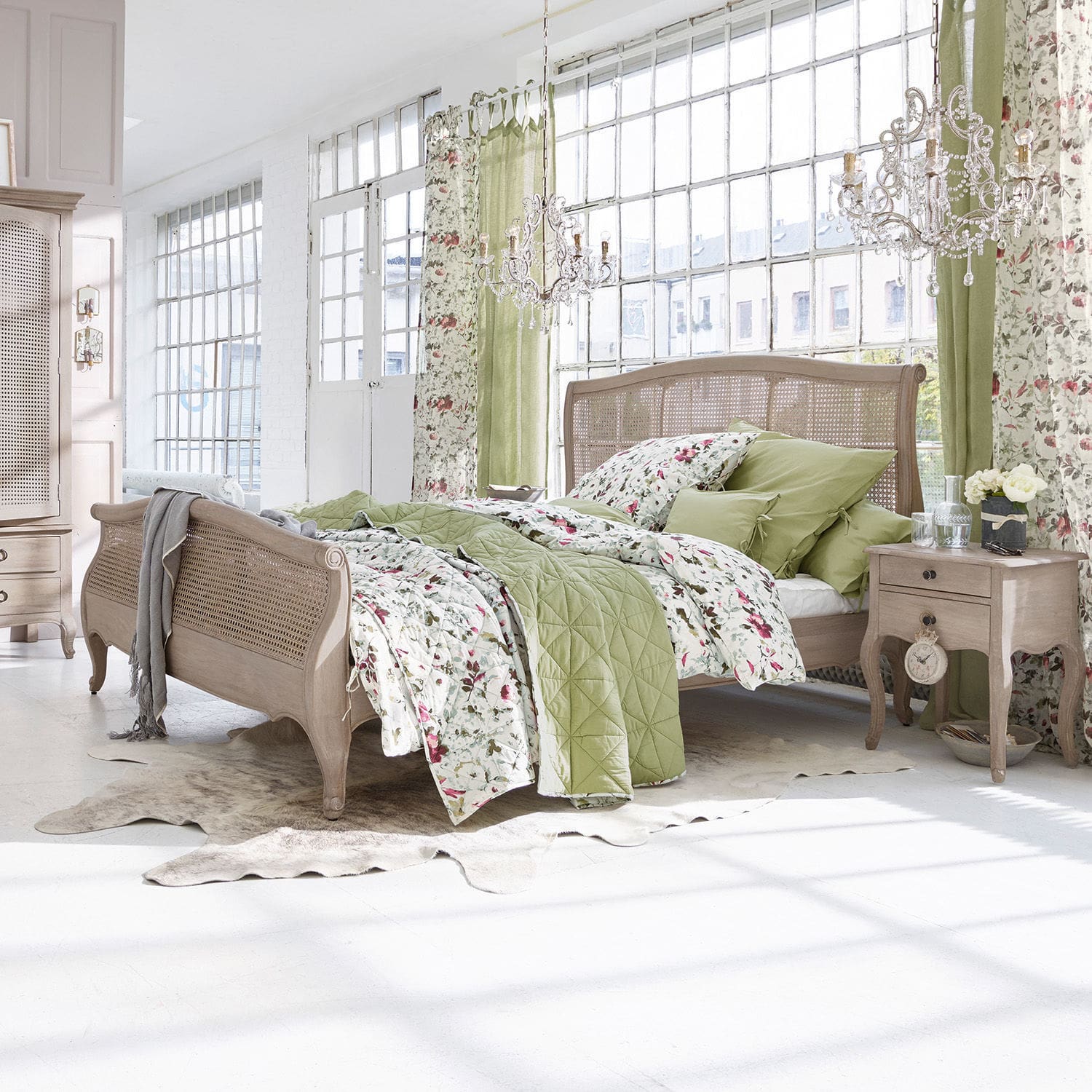 Bett Truso Schlafzimmer mit Holzbett und grün-blumiger Bettwäsche in hellem, natürlichem Stil