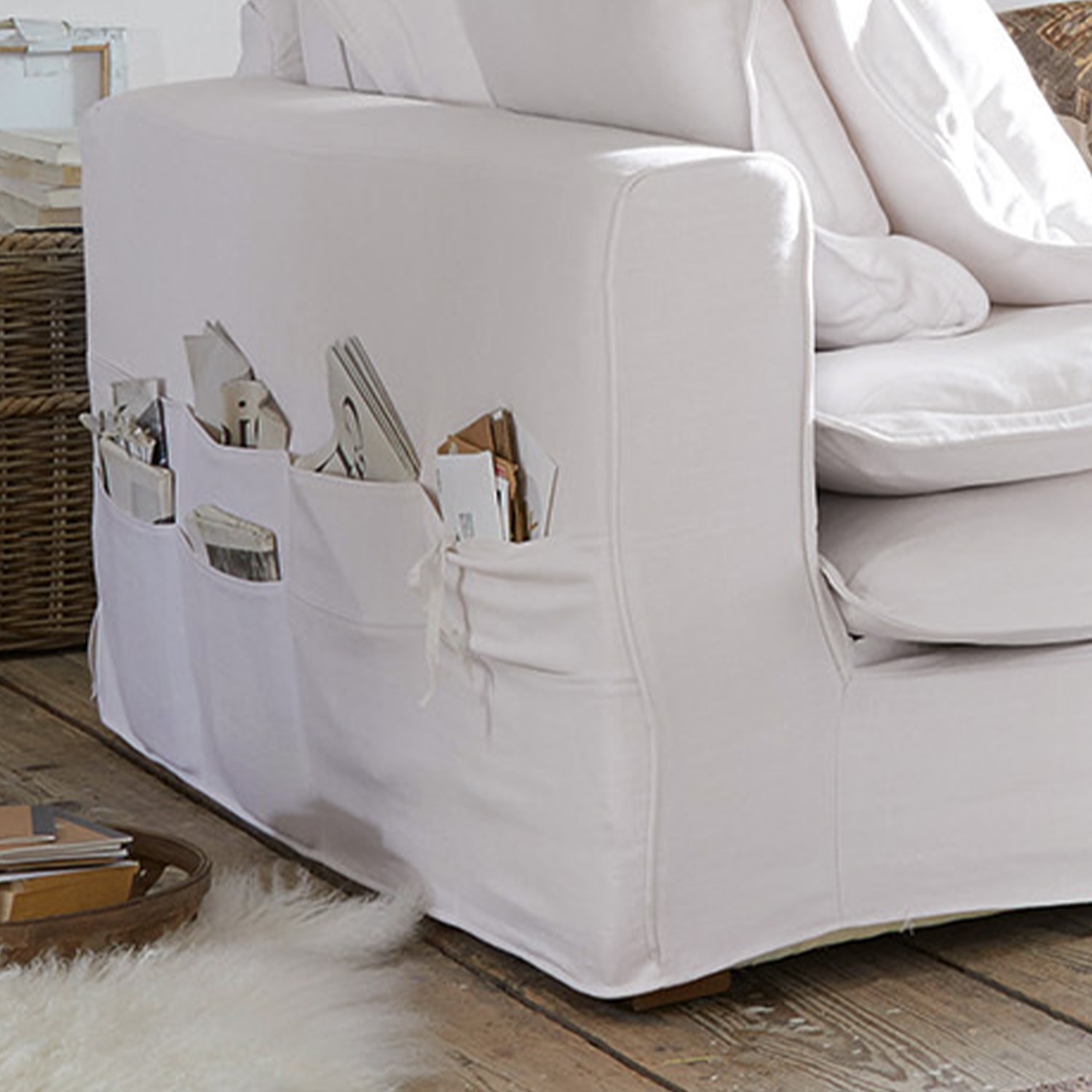 Weißes Baumwollsofa mit praktischen Seitentaschen für Magazine und Bücher im Wohnzimmer