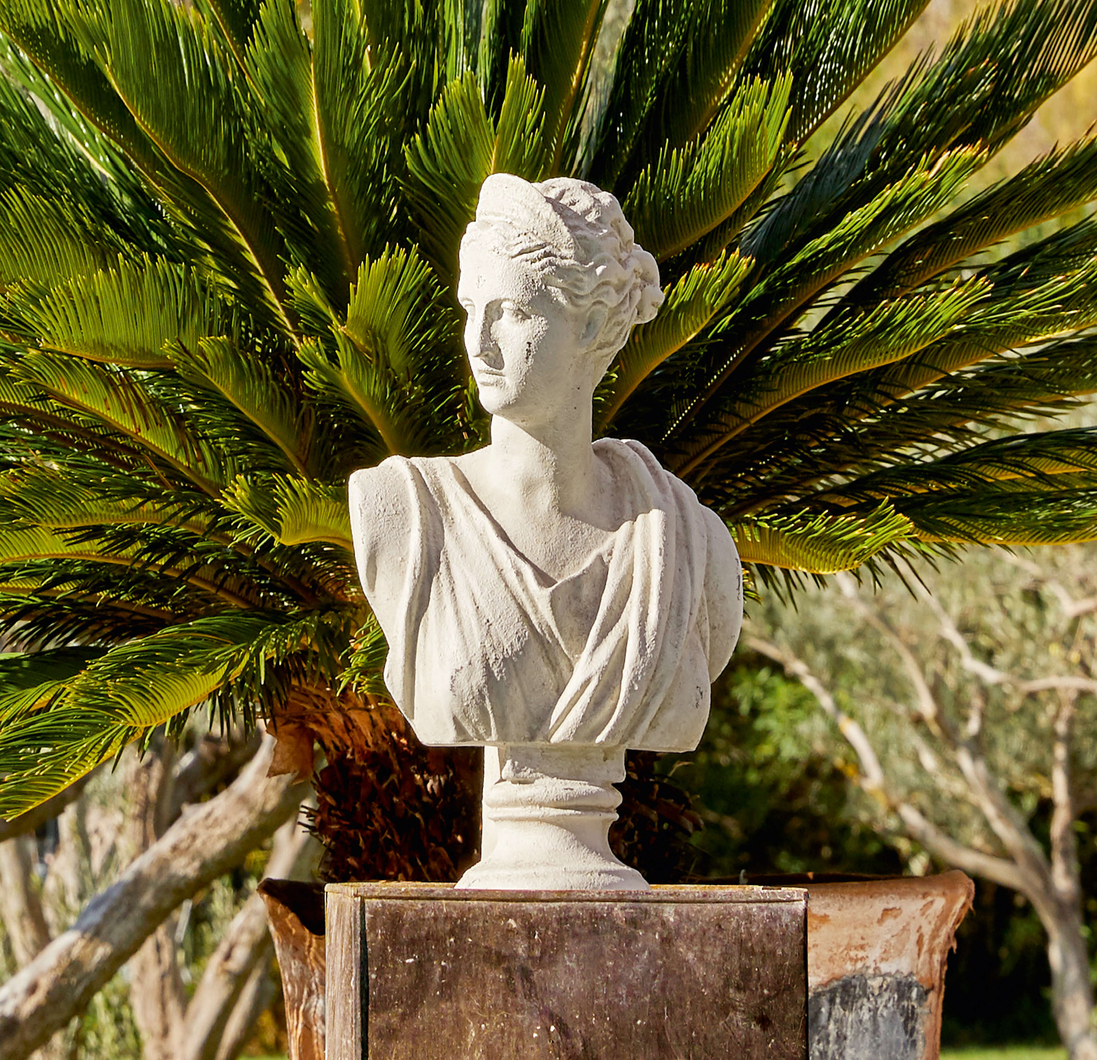 Weißes Steinguss-Büstenportrait einer Frau vor grünen Palmblättern, elegante Gartendekoration