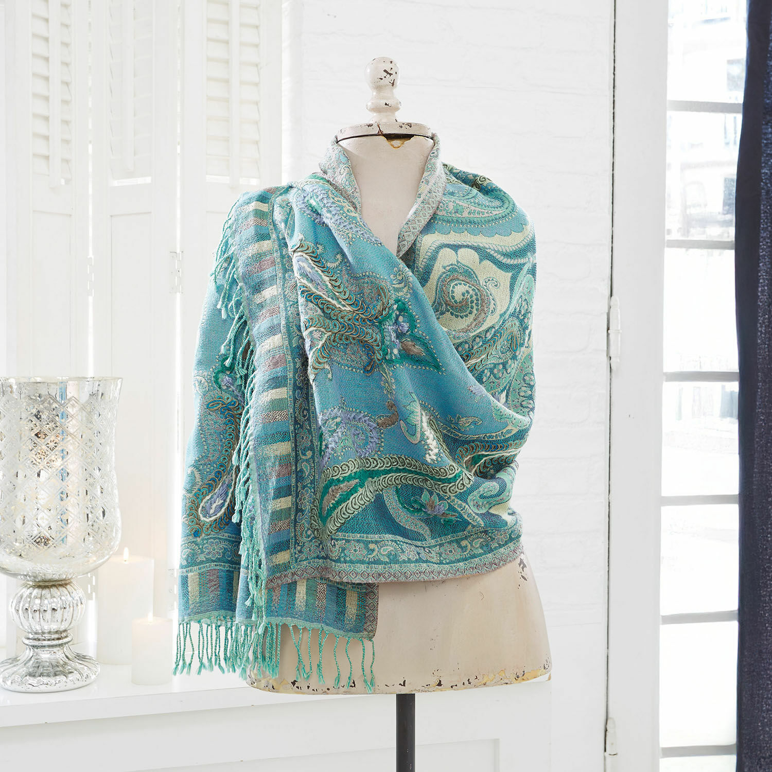 Schal Carol Türkisfarbener Paisley-Schal mit Fransen auf Schneiderpuppe in hellem Raum, Wohnaccessoire